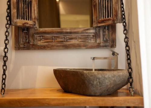 a bathroom with a stone sink and a mirror at Foga Hebrus in Ksamil