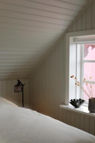 a bedroom with a bed and a window at Hótel Karólína in Stykkishólmur