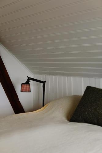 a bedroom with a bed with a lamp on it at Hótel Karólína in Stykkishólmur