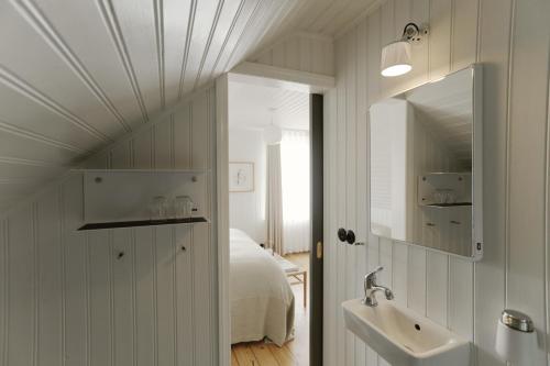 a bedroom with a bed and a sink and a mirror at Hótel Karólína in Stykkishólmur
