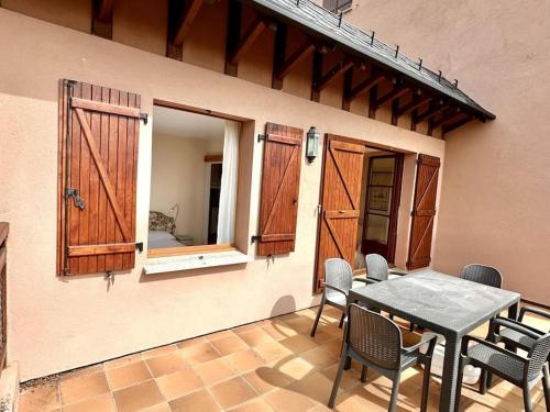 un patio avec une table, des chaises et une fenêtre dans l'établissement Apartamento en Enveitg, Montana Park, à Enveitg