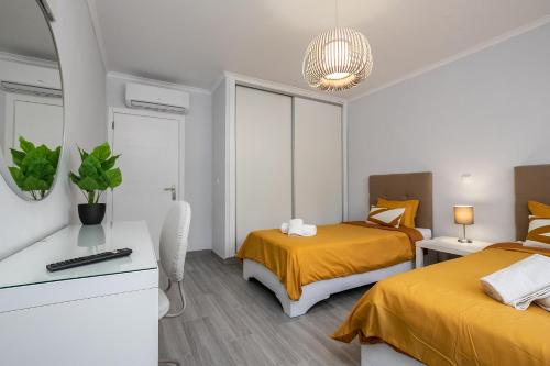 1 dormitorio con 2 camas y espejo en Apartment in São Rafael Albufeira Beach Resort, en Albufeira