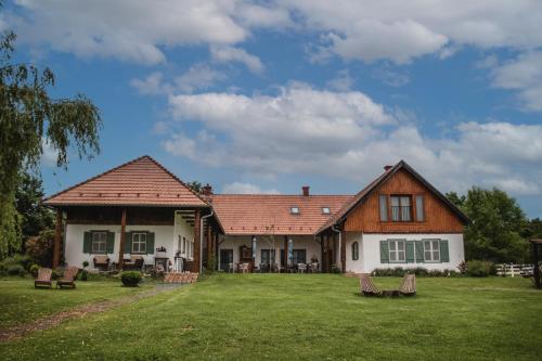une maison dotée d'une cour verdoyante avec des chaises. dans l'établissement Őri Art Inn, à Őriszentpéter