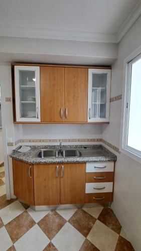una cocina vacía con fregadero y ventana en MS4 Apartamentos Nervión, en Sevilla
