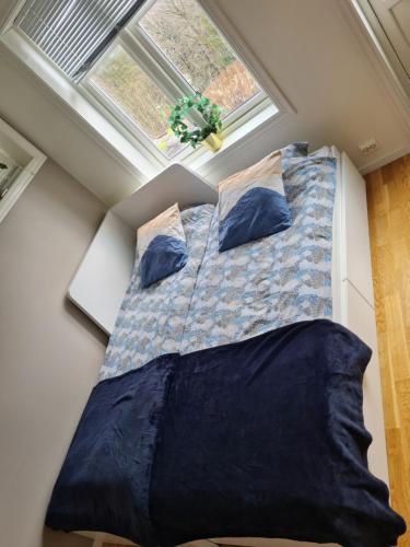 Bett in einem kleinen Zimmer mit Fenster in der Unterkunft Kaldvell Apartman in Lillesand
