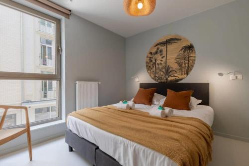 een slaapkamer met een groot bed en een groot raam bij City at Sea - Modern 1 bedroom apartement in Oostende