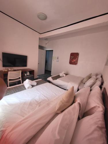 a hotel room with two beds and a television at Sunvilla beachfront hotel in Boracay