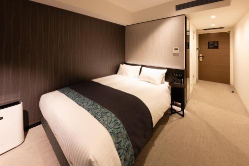 1 dormitorio con 1 cama grande en una habitación en Hotel Vischio Osaka-JR Hotel Group, en Osaka