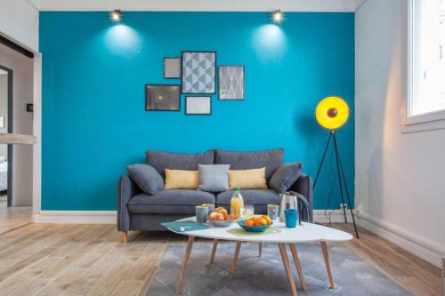 - un salon bleu avec un canapé et une table dans l'établissement Atlas - Ovalia, à Nîmes