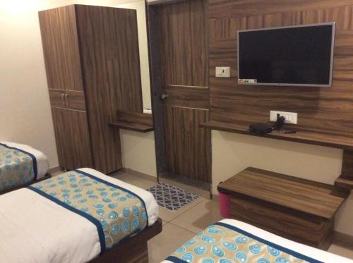 a hotel room with two beds and a flat screen tv at HOTEL RK PALACE in Ahmedabad