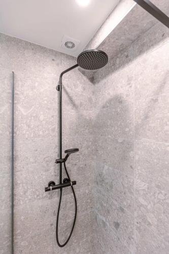 una ducha con cabezal de ducha en un baño en Huswell - Lovely apartment with lateral sea view and parking, en Ostende