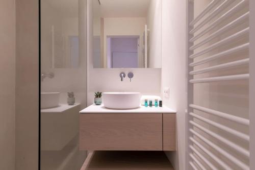 een witte badkamer met een wastafel en een spiegel bij Lovely 2 bedroom apartment in the heart of Knokke in Knokke-Heist