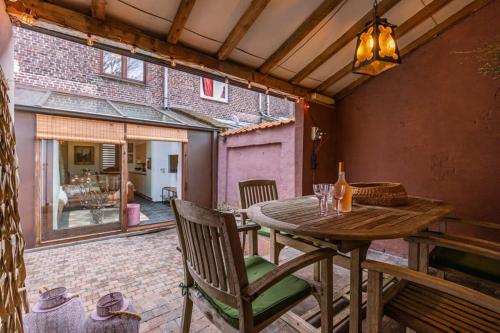 an outdoor patio with a wooden table and chairs at Huswell - Charming town-house in the center of Bruges in Bruges