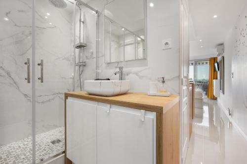 une salle de bain blanche avec un lavabo et une douche dans l'établissement La Dolce Vita naturiste Port Nature, au Cap d'Agde