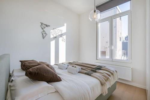 a bedroom with a bed with pillows and a window at House with large and sunny terrace in Antwerp