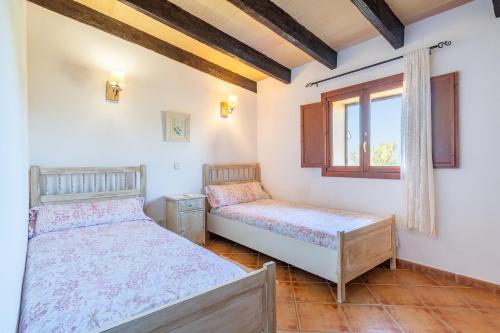 a bedroom with two beds and a window at Ses Oliveres in Campos