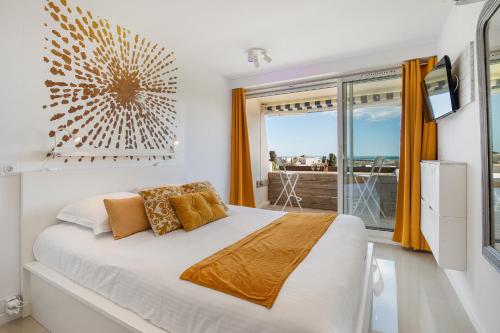 une chambre avec un grand lit et un balcon dans l'établissement La Dolce Vita naturiste Port Nature, au Cap d'Agde