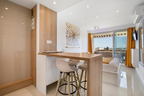 une cuisine avec une table et des tabourets dans une pièce dans l'établissement La Dolce Vita naturiste Port Nature, au Cap d'Agde