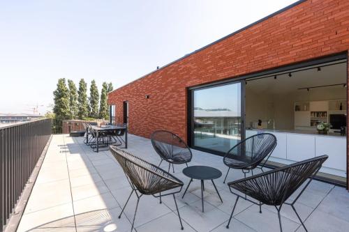 a group of chairs and tables on a patio at Huswell - Spacious apartment with beautiful terrace in Ghent in Ghent