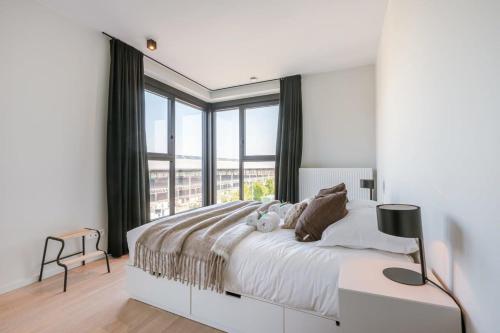a bedroom with a large bed with a large window at Spacious apartment with beautiful terrace near Ghent in Ghent