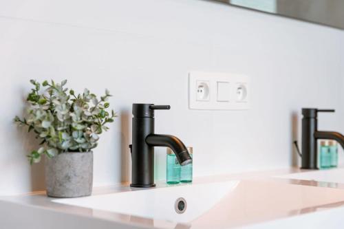 a bathroom sink with two faucets and a mirror at Spacious apartment with beautiful terrace near Ghent in Ghent