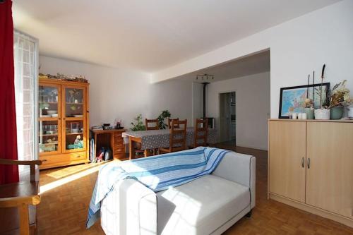 un salon avec un lit et une salle à manger dans l'établissement Pavillon Racine, à Le Mesnil-Saint-Denis