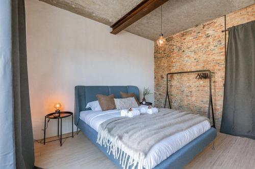 ein Schlafzimmer mit einem blauen Bett und einer Ziegelwand in der Unterkunft Industrial apartment with terrace in Antwerp in Antwerpen