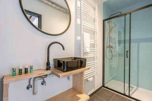 W łazience znajduje się prysznic, umywalka i lustro. w obiekcie Industrial apartment with terrace in Antwerp w Antwerpii