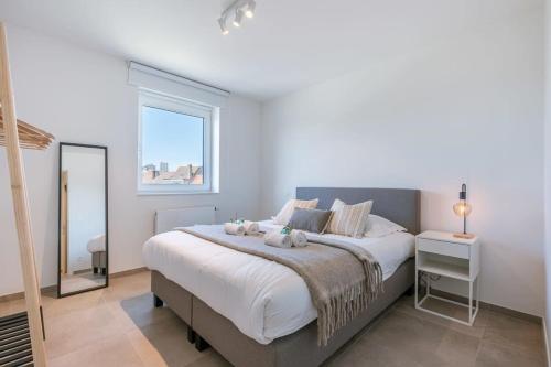 a bedroom with a large bed and a window at Pleasant apartment at the lighthouse in Ostend in Ostend