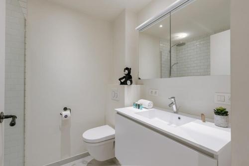 een witte badkamer met een wastafel en een toilet bij Modern 2 bedroom in centre of Knokke in Knokke-Heist