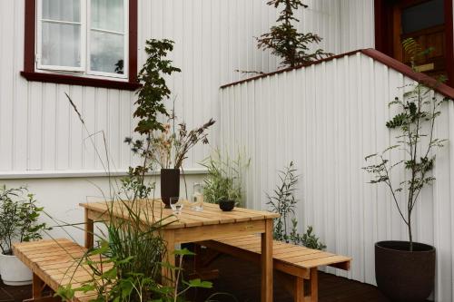a patio with a wooden table and potted plants at Hótel Karólína in Stykkishólmur