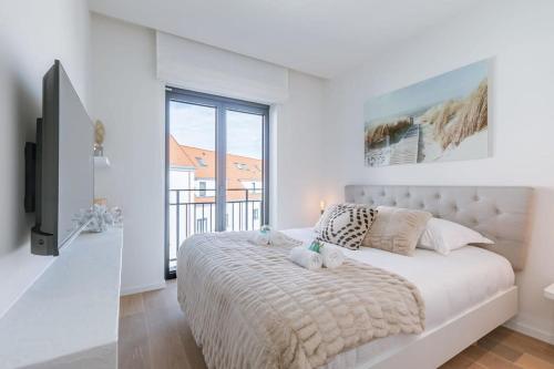 Exquisite apartment on a great location in Knokke في كنوك هايست: غرفة نوم مع سرير مع دبتين عليه