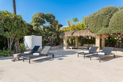a group of chaise lounge chairs in a patio at Huswell - Relax in luxury at this stunning seaside Villa in Calpe