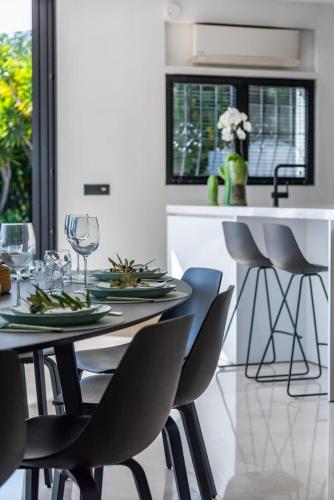 a dining room with a table and chairs with wine glasses at Huswell - Relax in luxury at this stunning seaside Villa in Calpe