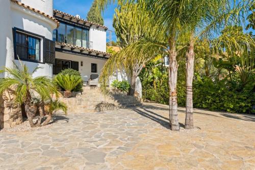 a house with palm trees in front of it at Huswell - Relax in luxury at this stunning seaside Villa in Calpe