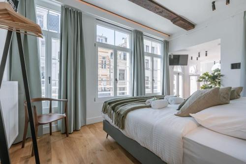 a bedroom with a large bed and large windows at Modern apartment in the centre of Antwerp in Antwerp
