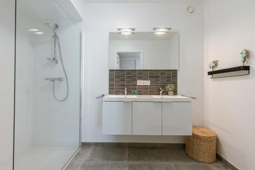 een badkamer met een wastafel en een spiegel bij Modern apartment with sunny terrace in Ostend in Oostende