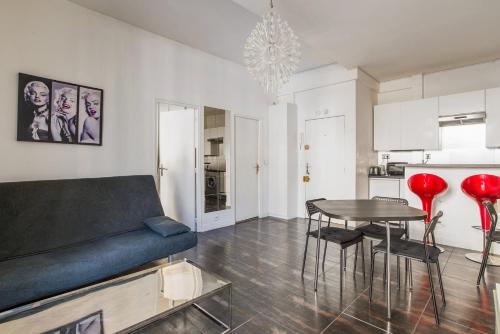 un salon avec un canapé bleu et une table dans l'établissement Paris St Germain Luxembourg, à Paris