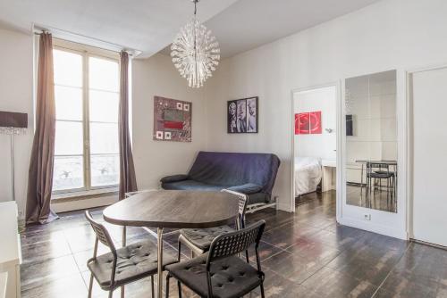 un salon avec une table et un canapé dans l'établissement Paris St Germain Luxembourg, à Paris