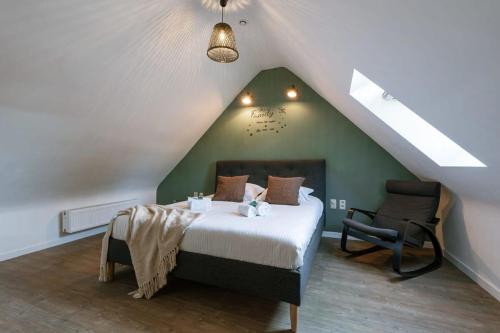 a bedroom with a bed and a chair in a attic at Great apartment in the heart of Ypres in Ieper