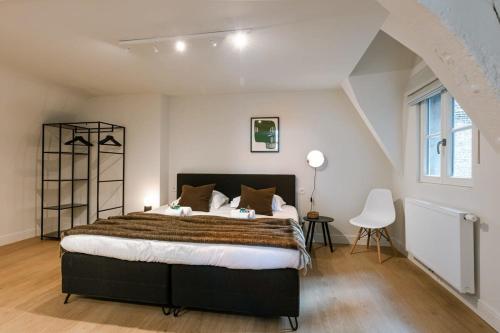 una camera da letto con un letto grande e una finestra di Huswell - Stunning apartment at the Grand Market of Antwerp ad Anversa