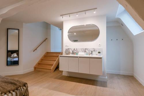 un bagno con lavandino e specchio di Huswell - Stunning apartment at the Grand Market of Antwerp ad Anversa