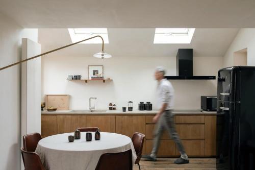 a man walking in a kitchen with a table at Inverenzie - Luxury farmhouse with mountain views 