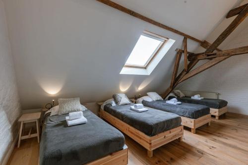 um quarto no sótão com 3 camas e uma janela em Beautiful apartment on top location in Ghent em Gent