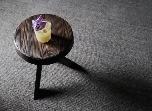 a wooden table with a glass with a purple flower on it at Gairnshiel lodge - Unique & exclusive lodge next to the castle in Ballater