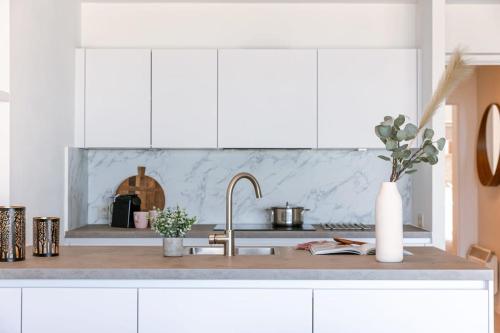 a kitchen counter with white cabinets and a sink at Frontal seaview apartment in Blankenberge in Blankenberge