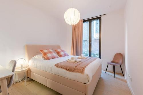 um quarto branco com uma cama e uma grande janela em Luxurious apartment nearby the city-centre of Ghent em Gante