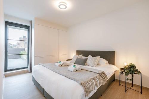 - une chambre avec un grand lit et des serviettes dans l'établissement Modern apartment located on the square of De Panne, à La Panne