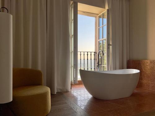 a large white tub in a room with a window at Zinar Castle in Krakow