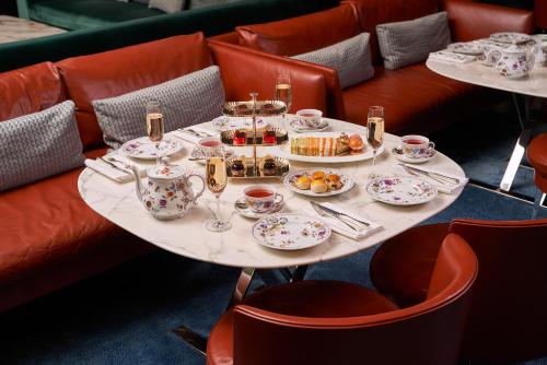 een tafel met bekers en borden met voedsel erop bij Bulgari Hotel London in Londen